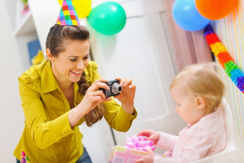 Mother making photos at babies birthday party